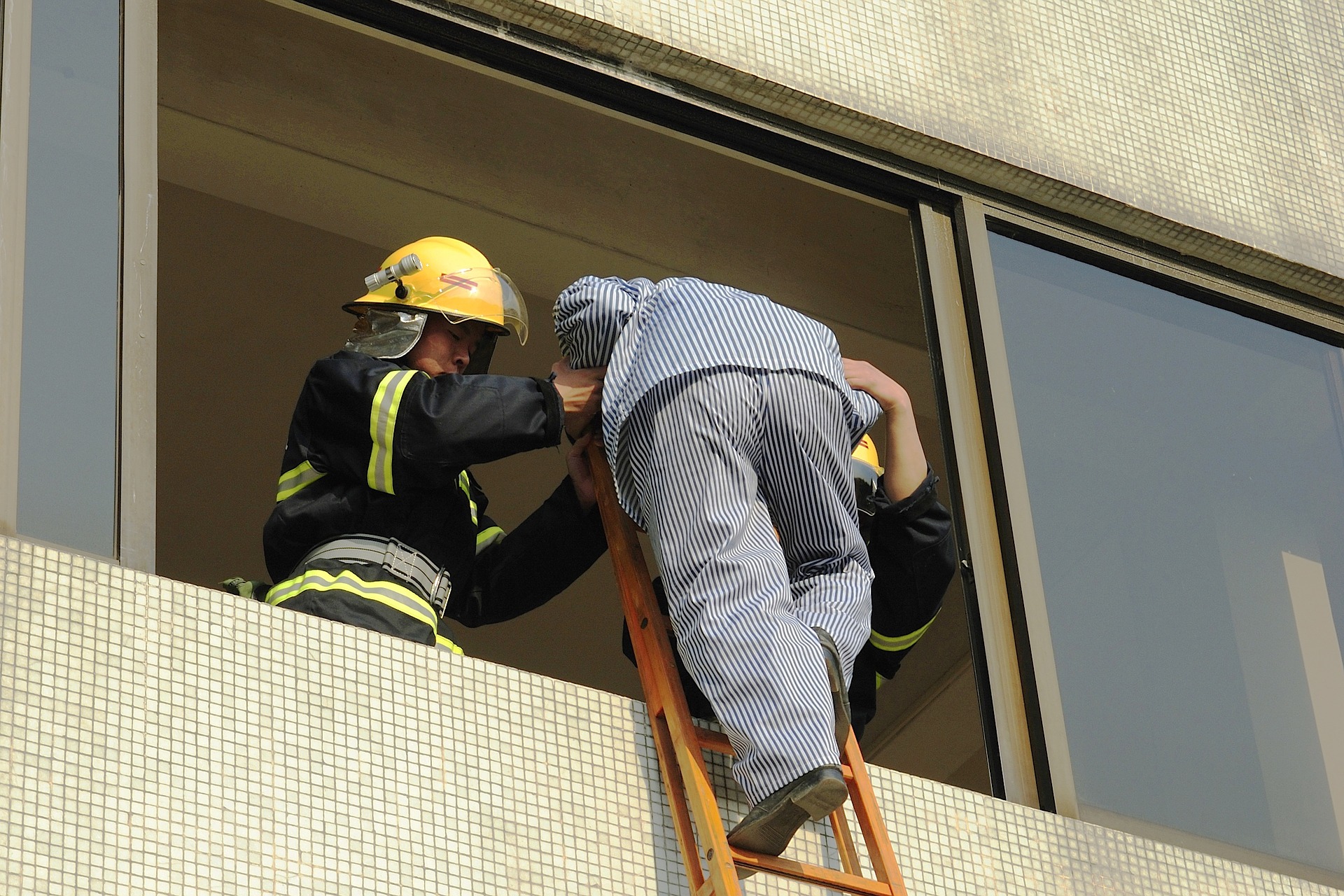 Fire fighter helping person out of window 