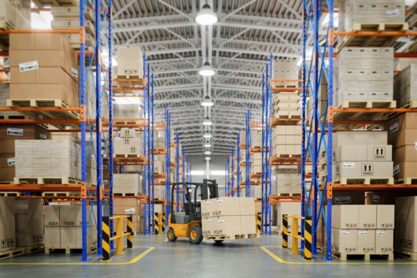 Forklift truck in warehouse or storage and shelves with cardboard boxes